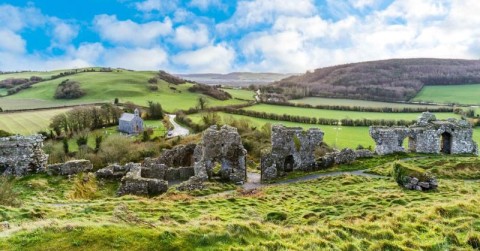 rolling green hills and stone houses in Ireland