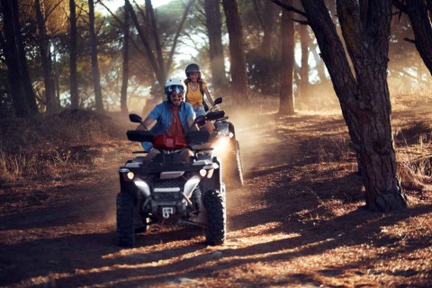 two people riding atvs